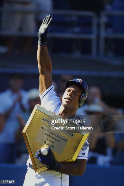 Rickey Henderson of the San Diego Padres holds a gold home plate after hitting a one-run home run in the third inning against the Los Angeles Dodgers...