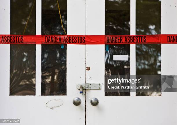 windows blocked with red danger asbestos tape - asbestos stock pictures, royalty-free photos & images