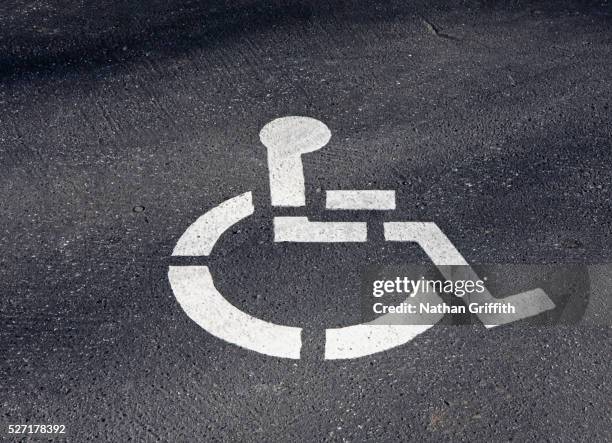 wheelchair figure stencilled on pavement - handicap parking space stock pictures, royalty-free photos & images