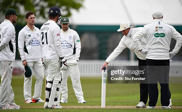 Umpires Neil Mallender and Michael Burns discuss the light during day two of the Specsavers County Championship Division Two match between...