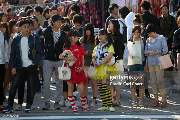 Girls in bright outfits wait to cross the road on April 30, 2016 in the Harajuku area of Tokyo, Japan. The Greater Tokyo Area is the most populous...