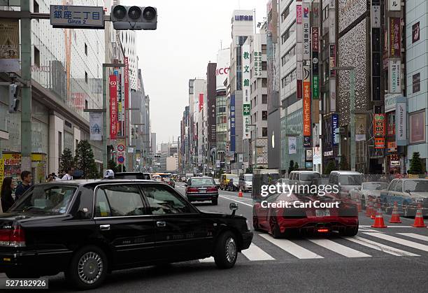 Lamborghini and taxi are driven on May 02, 2016 in the Ginza area of Tokyo, Japan. The Greater Tokyo Area is the most populous metropolitan area in...