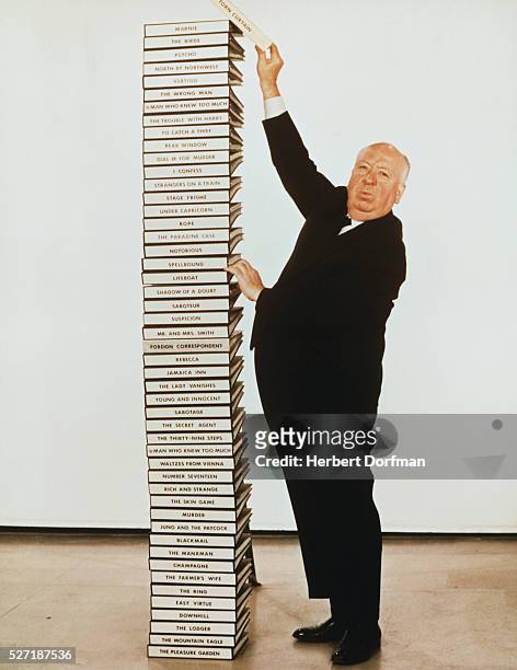 Alfred Hitchcock and a Stack of His Scripts