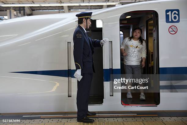 Woman speaks to a guard after boarding a Shinkansen bullet train at Tokyo Train Station on May 02, 2016 in Tokyo, Japan. The Shinkansen is a network...