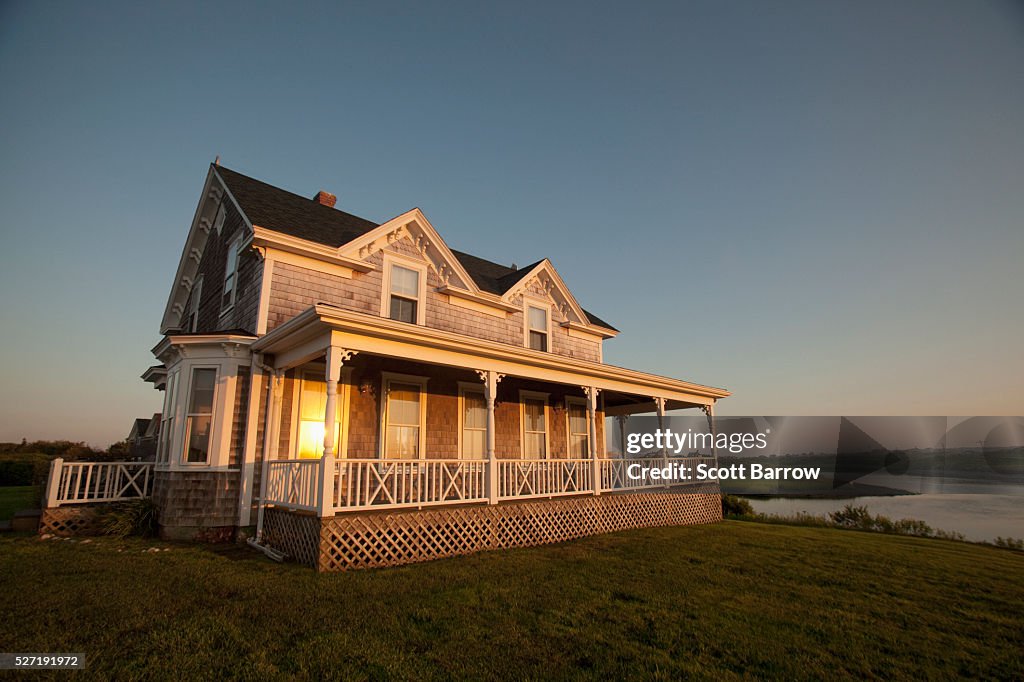 Reflection of setting sun on windows of cottage