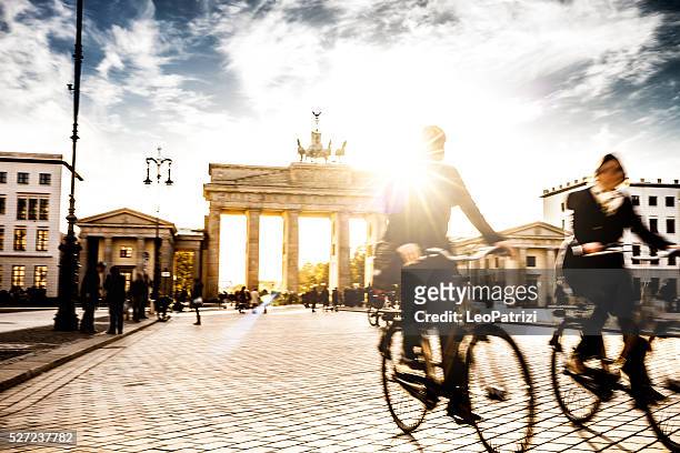berlin - people cycling at brandenburg gate - berlin brandenburger tor stockfoto's en -beelden