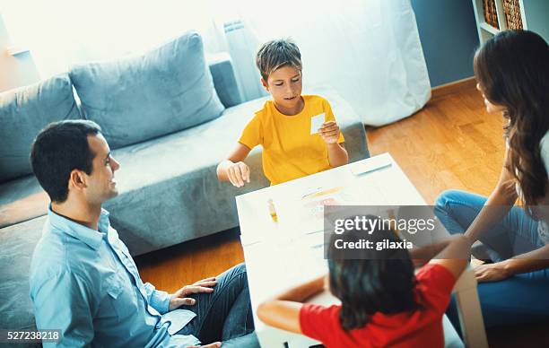 family playing board game at home. - game night stock pictures, royalty-free photos & images