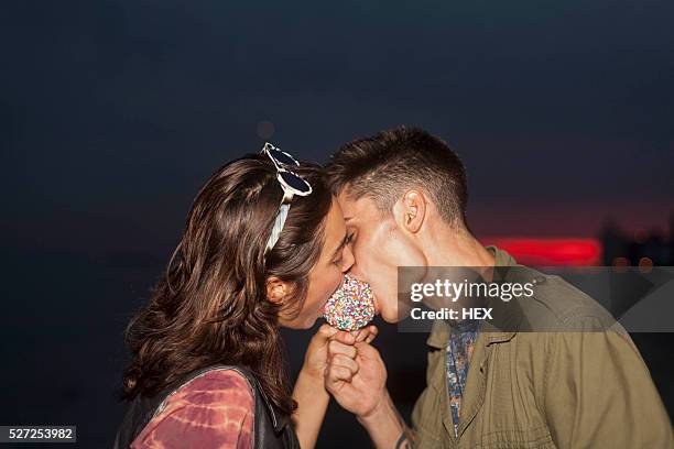 young couple sharing a candy apple - karamell stock-fotos und bilder