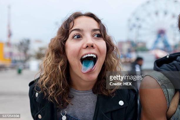 young woman sticking out her blue tongue - sticking out tongue stock pictures, royalty-free photos & images
