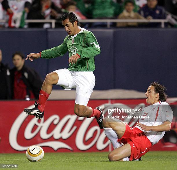 Miguel Zepeda of Mexico jumps over Dariusz Dudka of Poland during an international friendly on April 27, 2005 at Soldier Field in Chicago, Illinois.