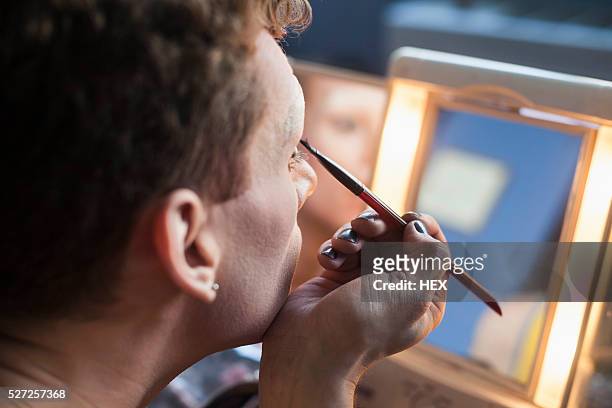young man applying drag makeup - drag queen stockfoto's en -beelden