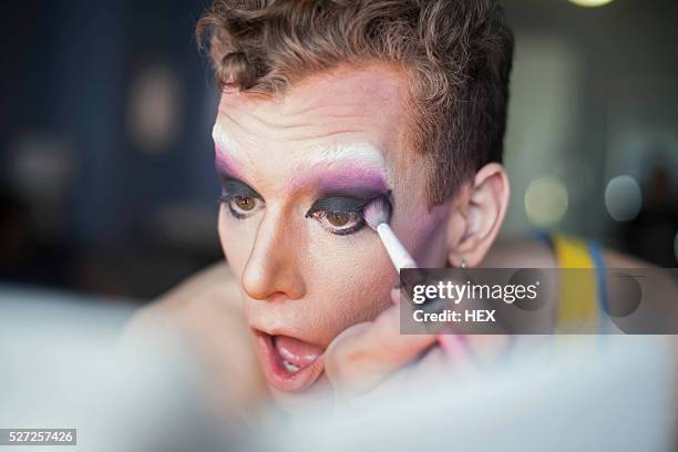 young man applying drag makeup - drag queen stock-fotos und bilder