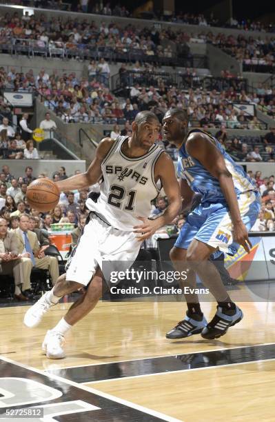 Tim Duncan of the San Antonio Spurs drives against Nene of the Denver Nuggets in Game two of the Western Conference Quarterfinals during the 2005 NBA...