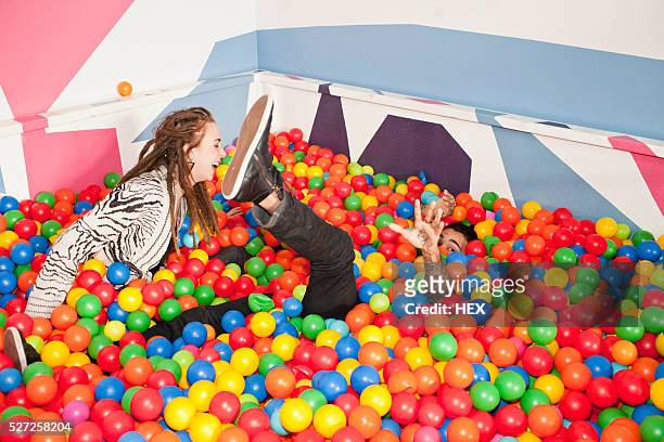 friends playing in a ball pit - adult ball pit stock-fotos und bilder