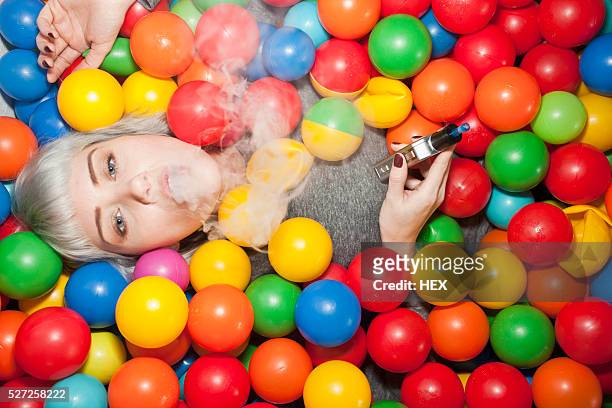 young woman in a ball pit - adult ball pit stock-fotos und bilder