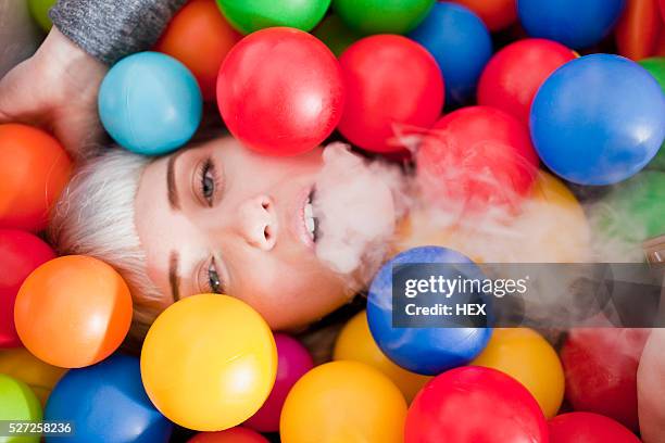 young woman in a ball pit - adult ball pit stock-fotos und bilder