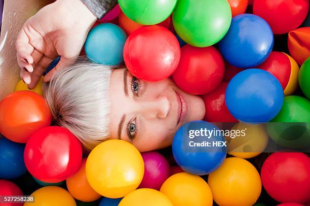 young woman in a ball pit - adult ball pit stock pictures, royalty-free photos & images