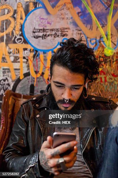 young man using a cell phone - pierced stock pictures, royalty-free photos & images