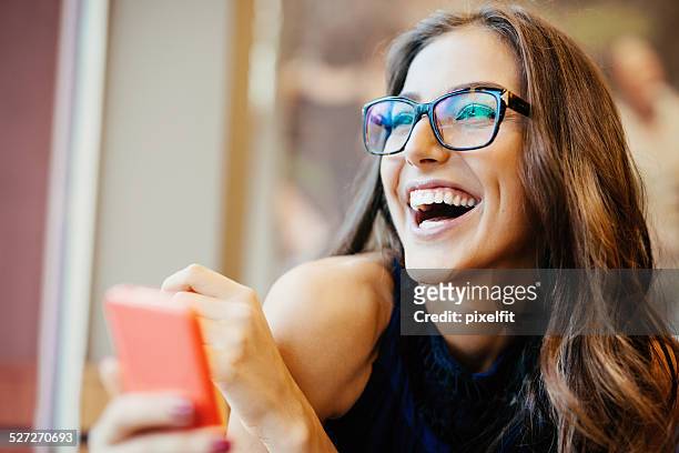 junge frau sms auf smart phone - glasses woman stock-fotos und bilder