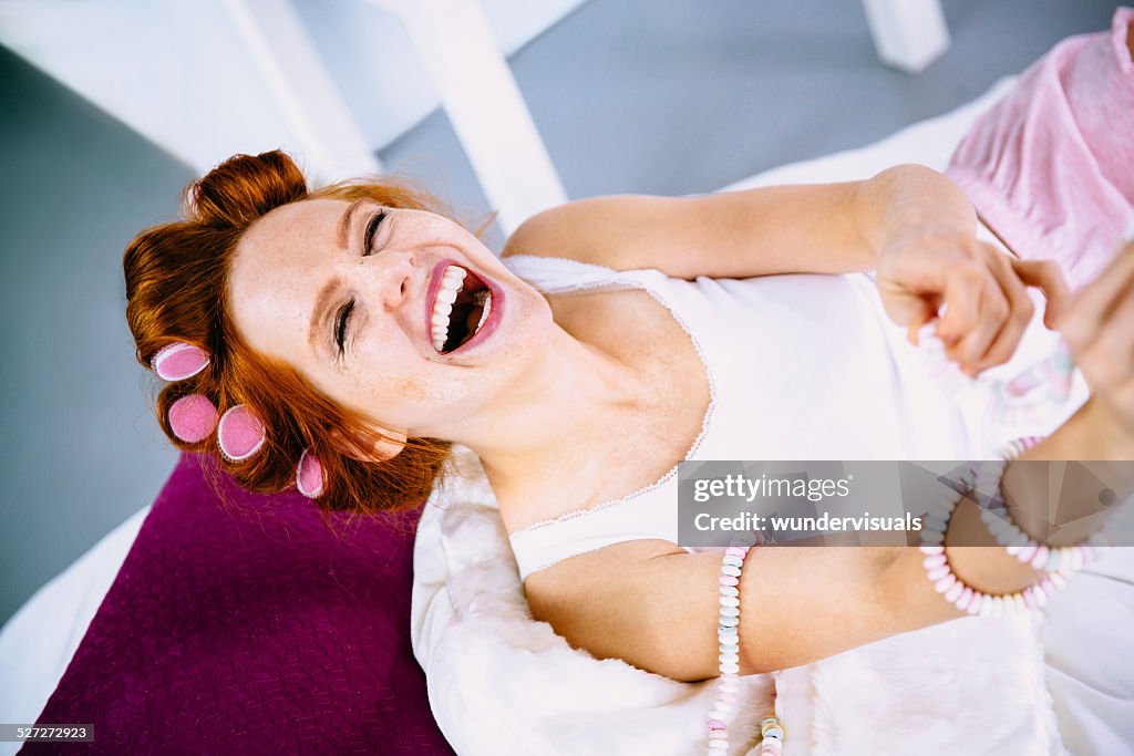 Young Woman Lies In Bed And Plays With Candy