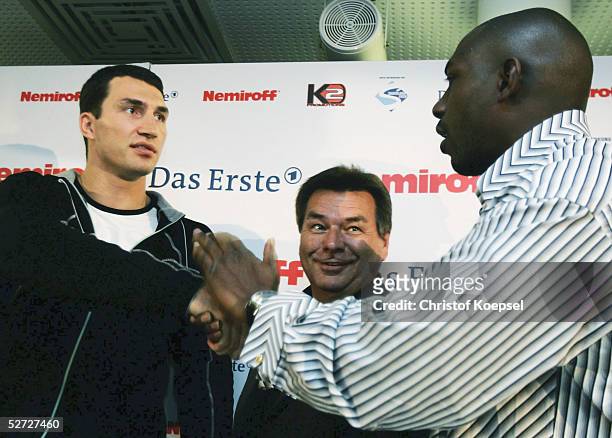 Wladimir Klitschko of Ukraine shakes hands with Eliseo Castillo of Cuba as ARD television Waldemar Hartmann looks on during a press conference on...