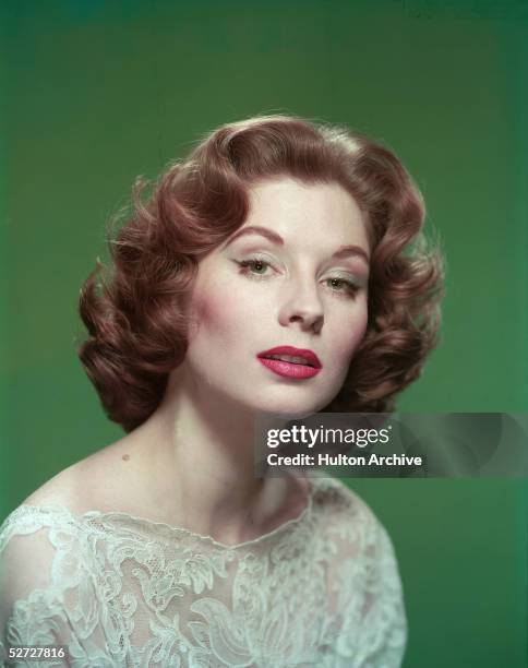 Portrait of American model and actress Suzy Parker as she wears a lace blouse, 1950s.