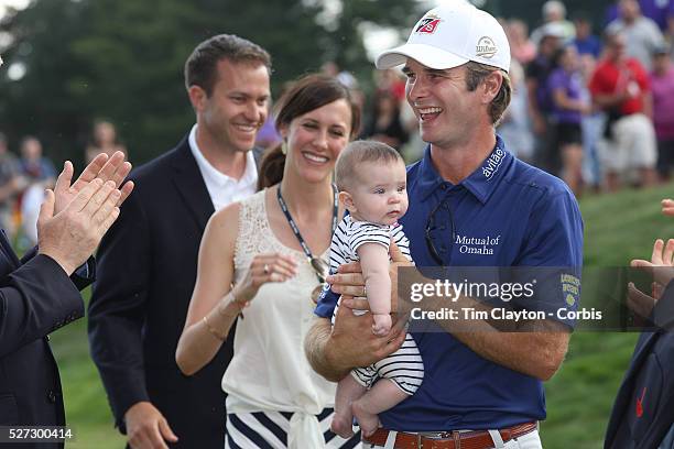 Kevin Streelman holding his 6-month-old daughter Sophia, watched by his wife Courtney after winning the Travelers Championship at the TPC River...