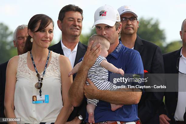 Kevin Streelman holding his 6-month-old daughter Sophia, watched by his wife Courtney after winning the Travelers Championship at the TPC River...