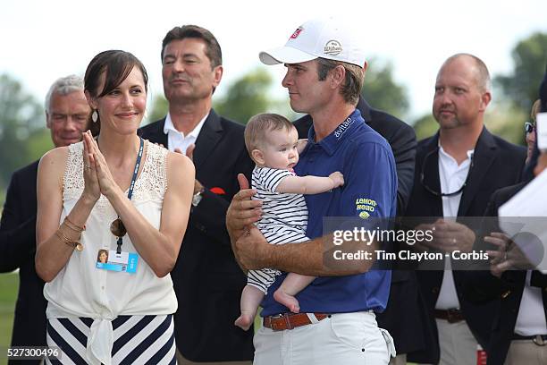 Kevin Streelman holding his 6-month-old daughter Sophia, watched by his wife Courtney after winning the Travelers Championship at the TPC River...