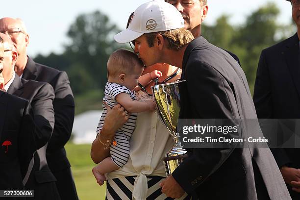 Kevin Streelman kisses his 6-month-old daughter Sophia, watched by his wife Courtney after winning the Travelers Championship at the TPC River...