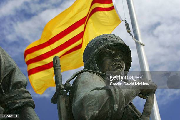 An old-style Vietnamese flag flies over a statue depicting a South Vietnamese soldier at the Vietnam War Memorial on April 28, 2005 near the Little...