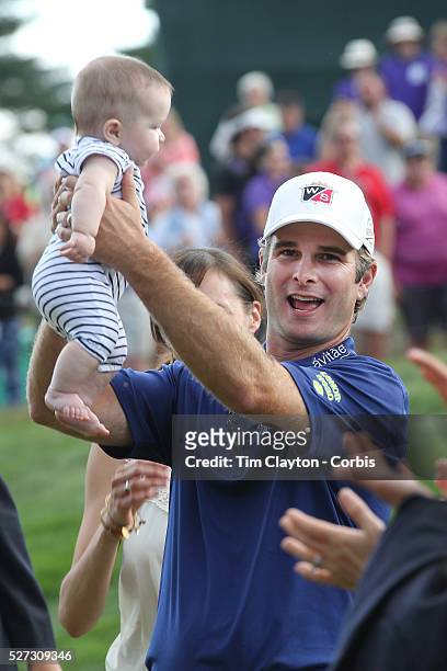 Kevin Streelman holding his 6-month-old daughter Sophia, watched by his wife Courtney after winning the Travelers Championship at the TPC River...