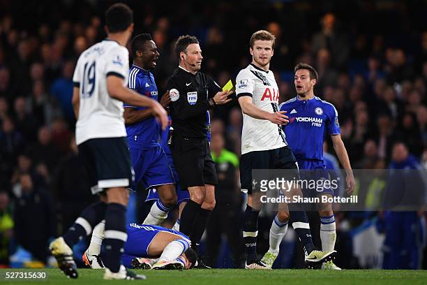 Referee Mark Clattenburg shows a yellow card to Eric Dier of Tottenham Hotspur after bringing down Eden Hazard of Chelsea during the Barclays Premier...