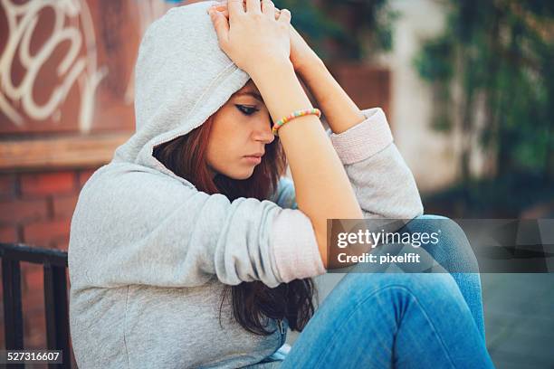 depressed teen girl sitting lonely - family problems stock pictures, royalty-free photos & images