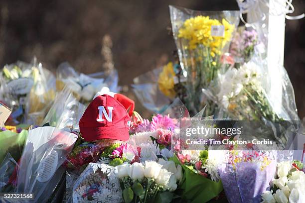 Baseball hat amongst the flowers at he shrine under the school sign in Sandy Hook after yesterday's shootings at Sandy Hook Elementary School,...