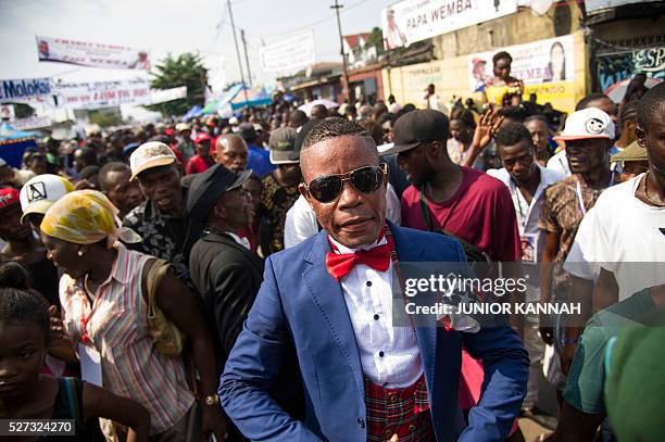 Member of La SAPE movement gathers with others in the streets of 'Village Molokoi', in the Matonge neighborhood of Kinshasa, to pay tribute to late...