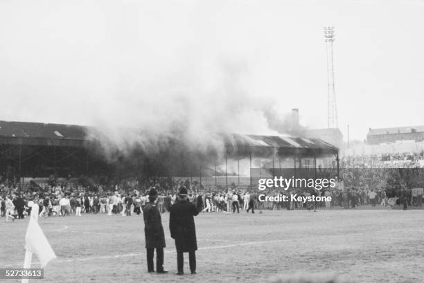 Crowds on the pitch at Bradford City's Valley Parade stadium after the stand caught fire. In less than five minutes the whole Main Stand was ablaze...