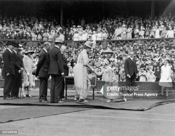 King George V opens Wimbledon's Jubilee Tennis Championships, June 1926. French player Suzanne Lenglen shakes the hand of royal consort Queen Mary.