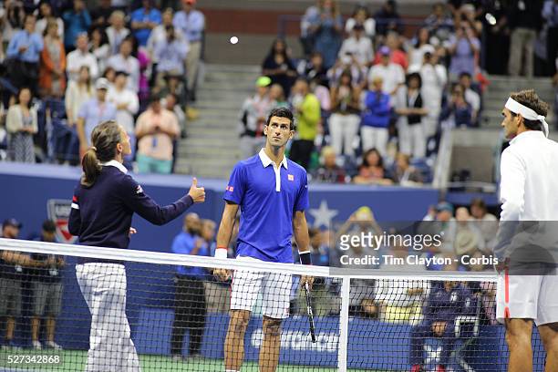 Eva Asderaki-Moore of Greece, the first female chair umpire for a U.S. Open men's singles final, tosses the coin before the start of the Roger...