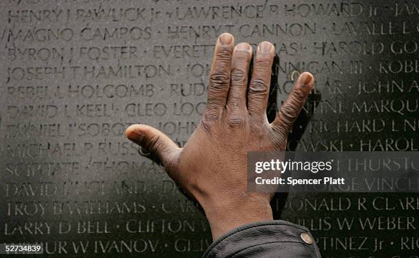 Man places his hand on the Vietnam Veterans Memorial where the names of 58 thousand Americans killed in the Vietnam War are listed April 29, 2005 in...