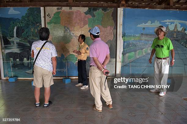 This photo taken on February 17, 2016 shows tourists looking at paintings inside the former Khmer Rouge commander Ta Mok's house in the Anlong Veng...