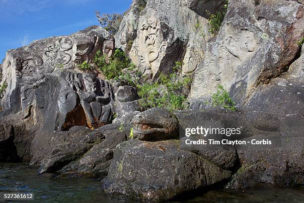 Maori rock carvings at Mine Bay, Lake Taupo. The Maori rock carvings are over 10 metres high and are only accessible by boat. The carving has become...