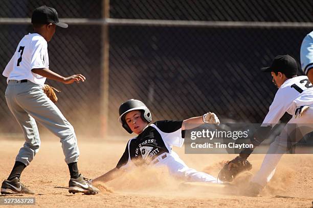 Young baseball player slides into second base during the Norwalk Little League baseball competition at Broad River Fields, Norwalk, Connecticut. USA....