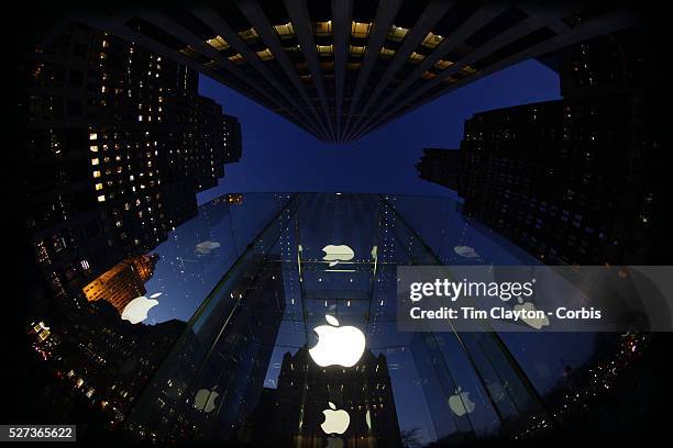 The Apple Logo, on the glass fronted Apple Store, surrounded by the high rise buildings of Manhattan opposite Central Park on Fifth Avenue,...