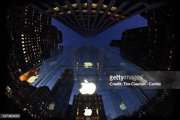 The Apple Logo, on the glass fronted Apple Store, surrounded by the high rise buildings of Manhattan opposite Central Park on Fifth Avenue,...