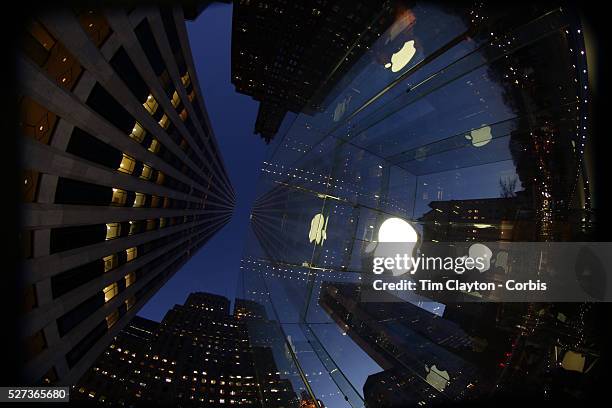 The Apple Logo, on the glass fronted Apple Store, surrounded by the high rise buildings of Manhattan opposite Central Park on Fifth Avenue,...