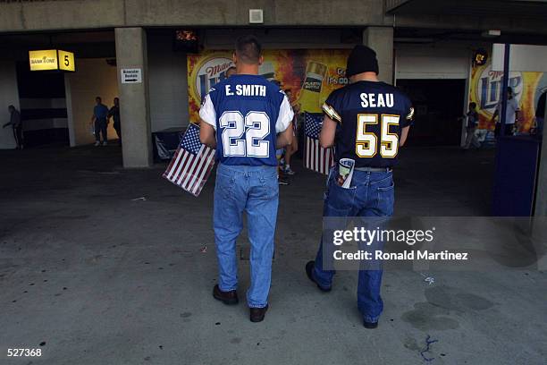 Football fans carry American flags into Texas Stadium before a game against the San Diego Chargers and Dallas Cowboys in Irving, Texas. Chargers...