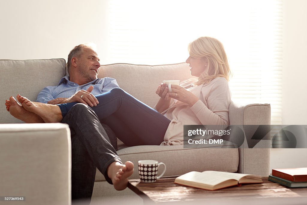 Couple talking in living room with coffee