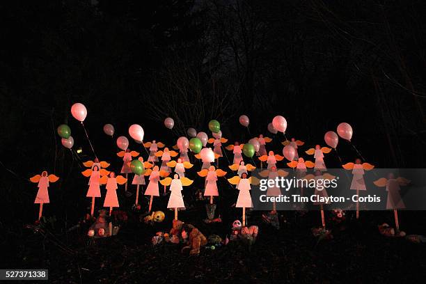 Night shot of twenty-seven wooden angel figures placed in a wooded area beside the road in Sandy Hook after the mass shootings at Sandy Hook...