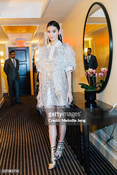 Chinese model Ming Xi wears a Michael Kors Collection white-and- silver sequin-and- ostrich feather-embroidered tweed organza shirtdress, Michael...